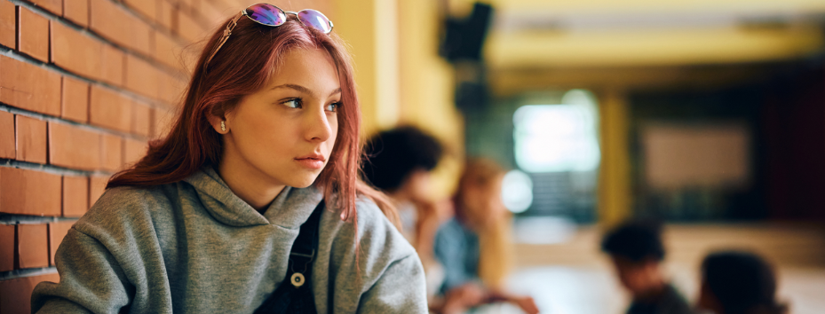 girl with pink hair at school looks into distance