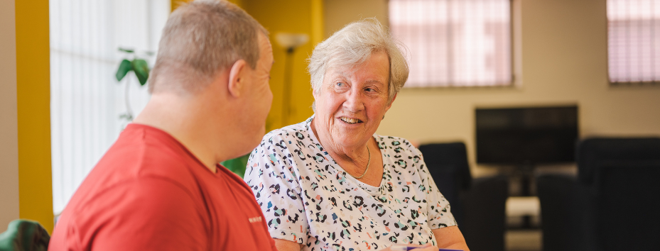 older woman talking to man in community centre